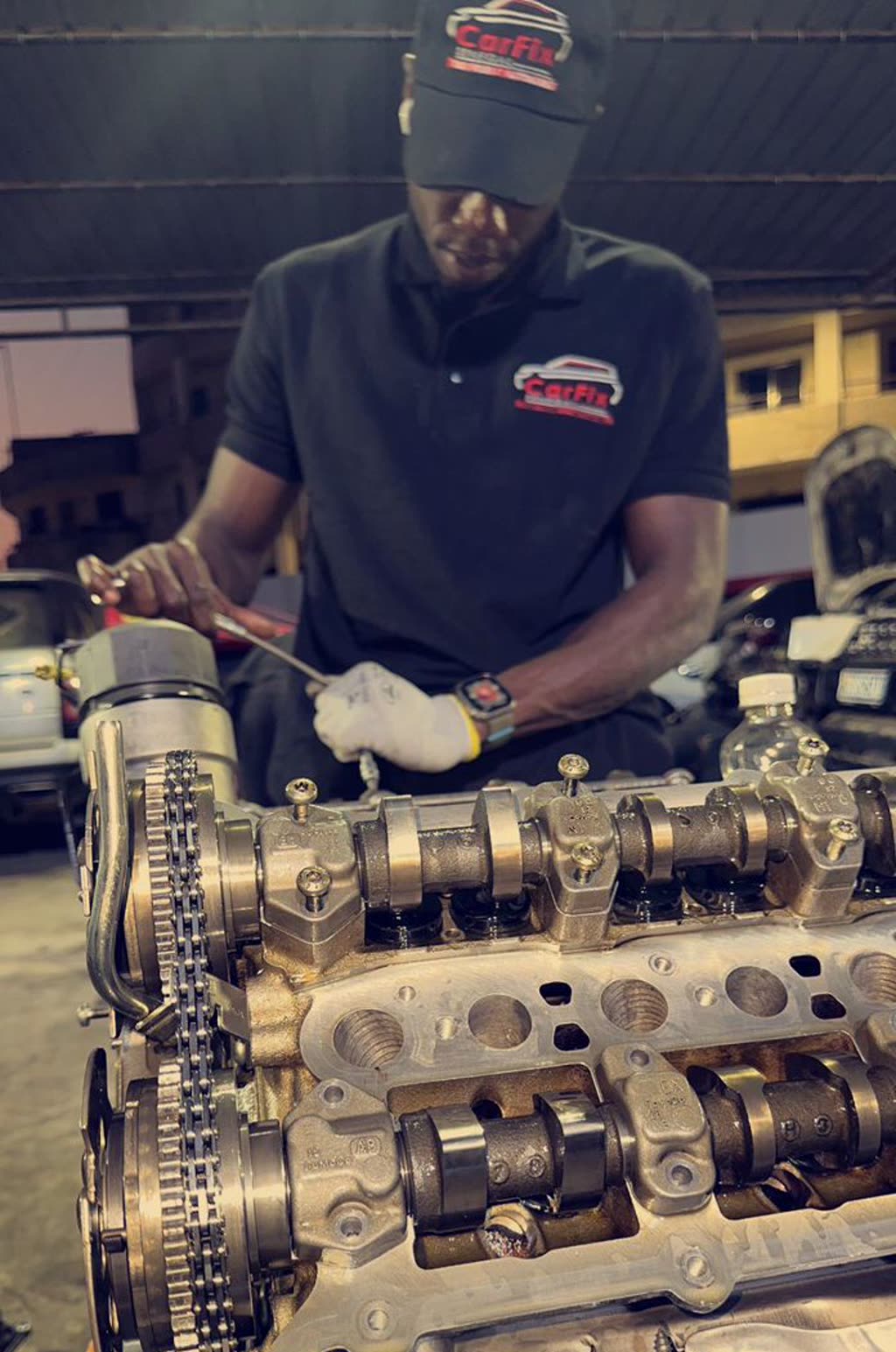 Technicien Carfix travaillant sur un moteur démonté